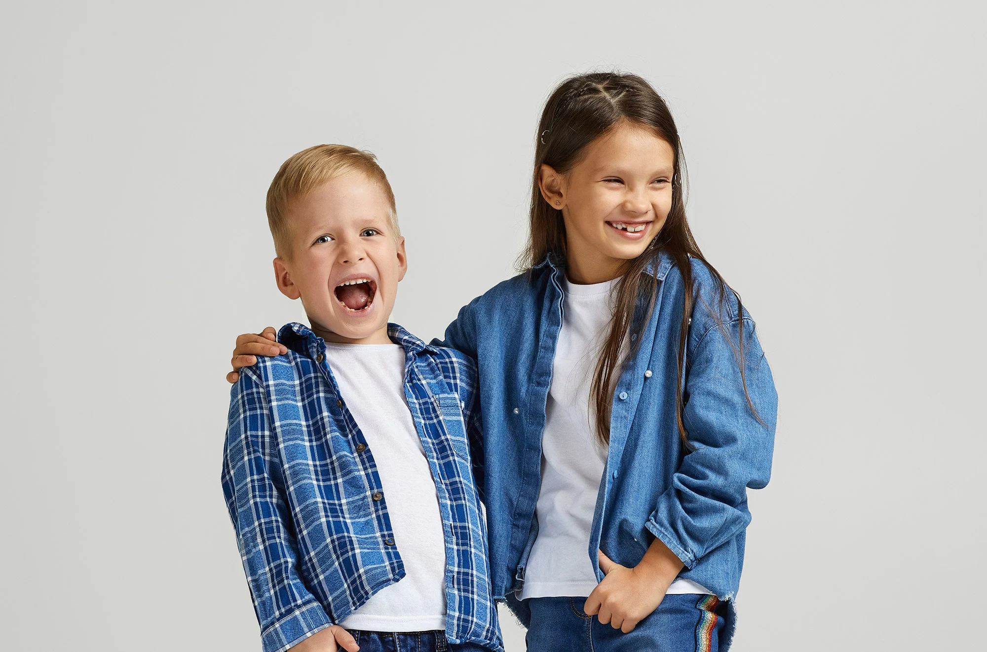Two children in denim smiling together in kids ministry