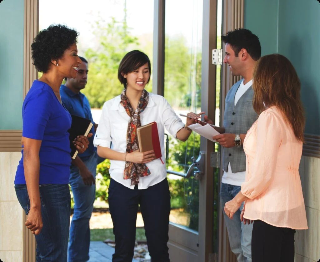 Volunteer greeters welcoming guests at the church doors