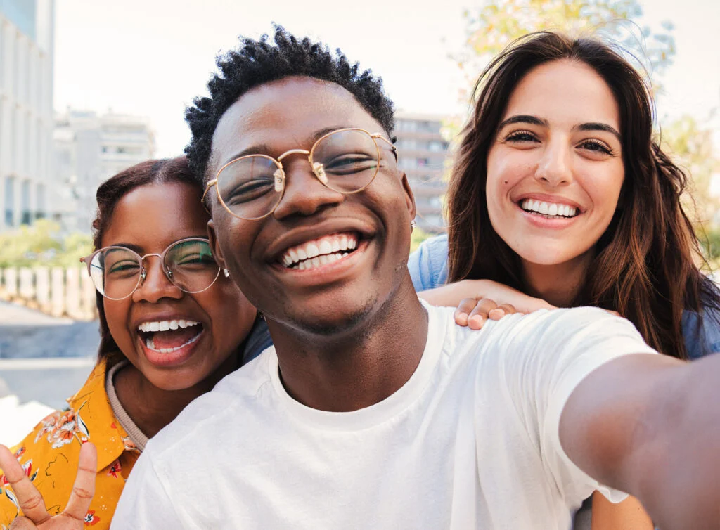 Smiling teens taking a group selfie